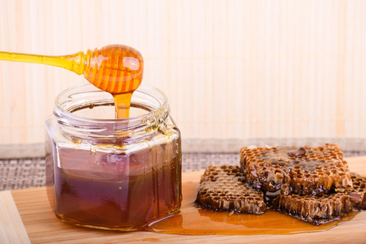 Jar of organic honey with honeycomb